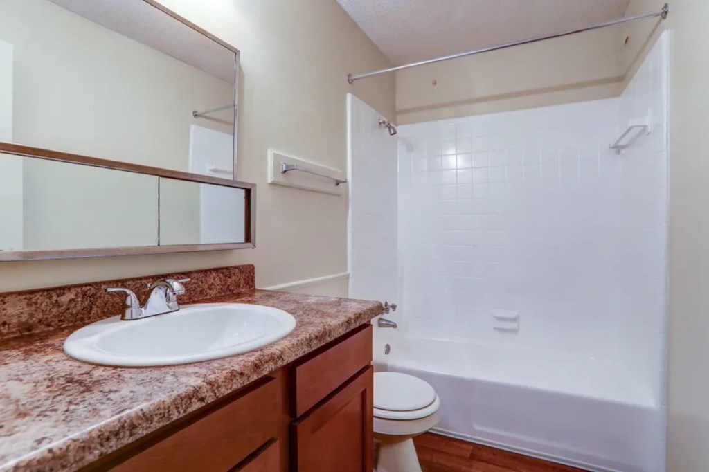 A bathroom with a sink, toilet, and bathtub.